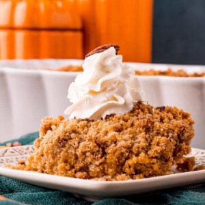 picture of pumpkin crisp on a plate with a drop of whipped cream on top