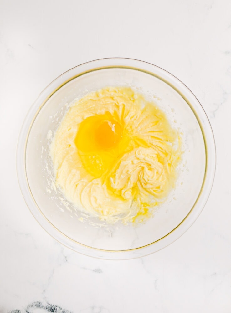 picture of creamed butter and sugar and an egg in a bowl 