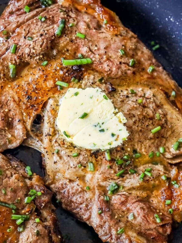 picture of steak in a pan with a pat of butter on top