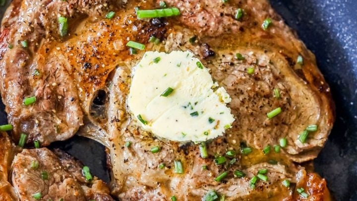picture of steak in a pan with a pat of butter on top