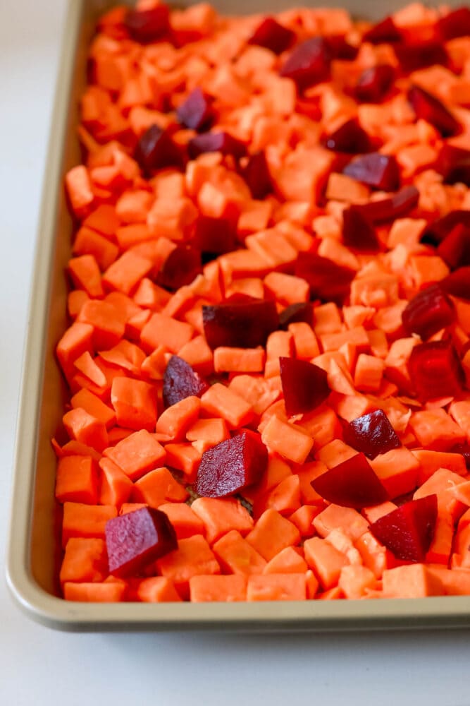 picture of raw sweet potato and beet cubes on a baking sheet