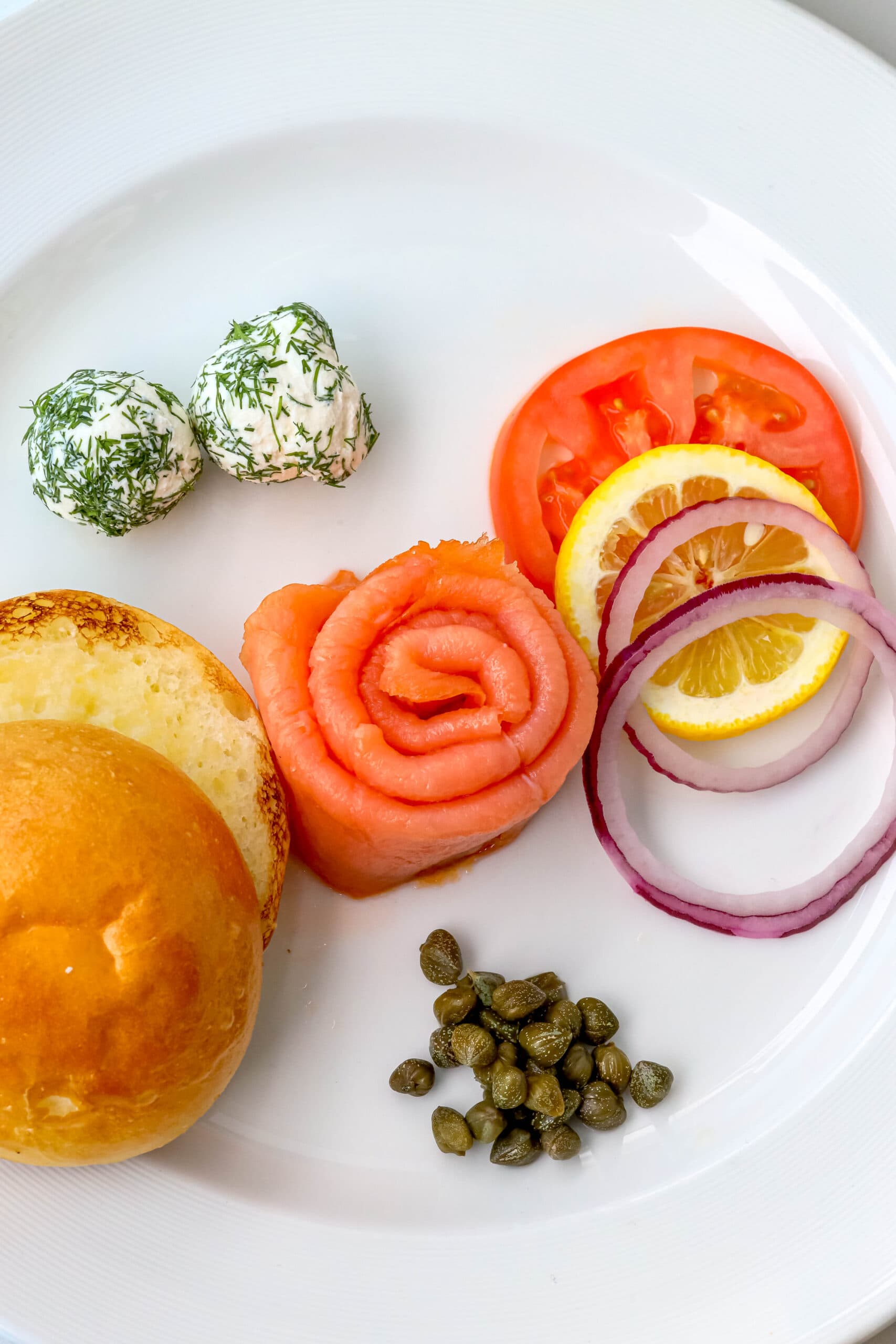 Your Ultimate Dining Guide for the Majestic Princess 41 A savory sandwich filled with fresh tomatoes, onions, and peppers, elegantly served on a white plate aboard the Majestic Princess.