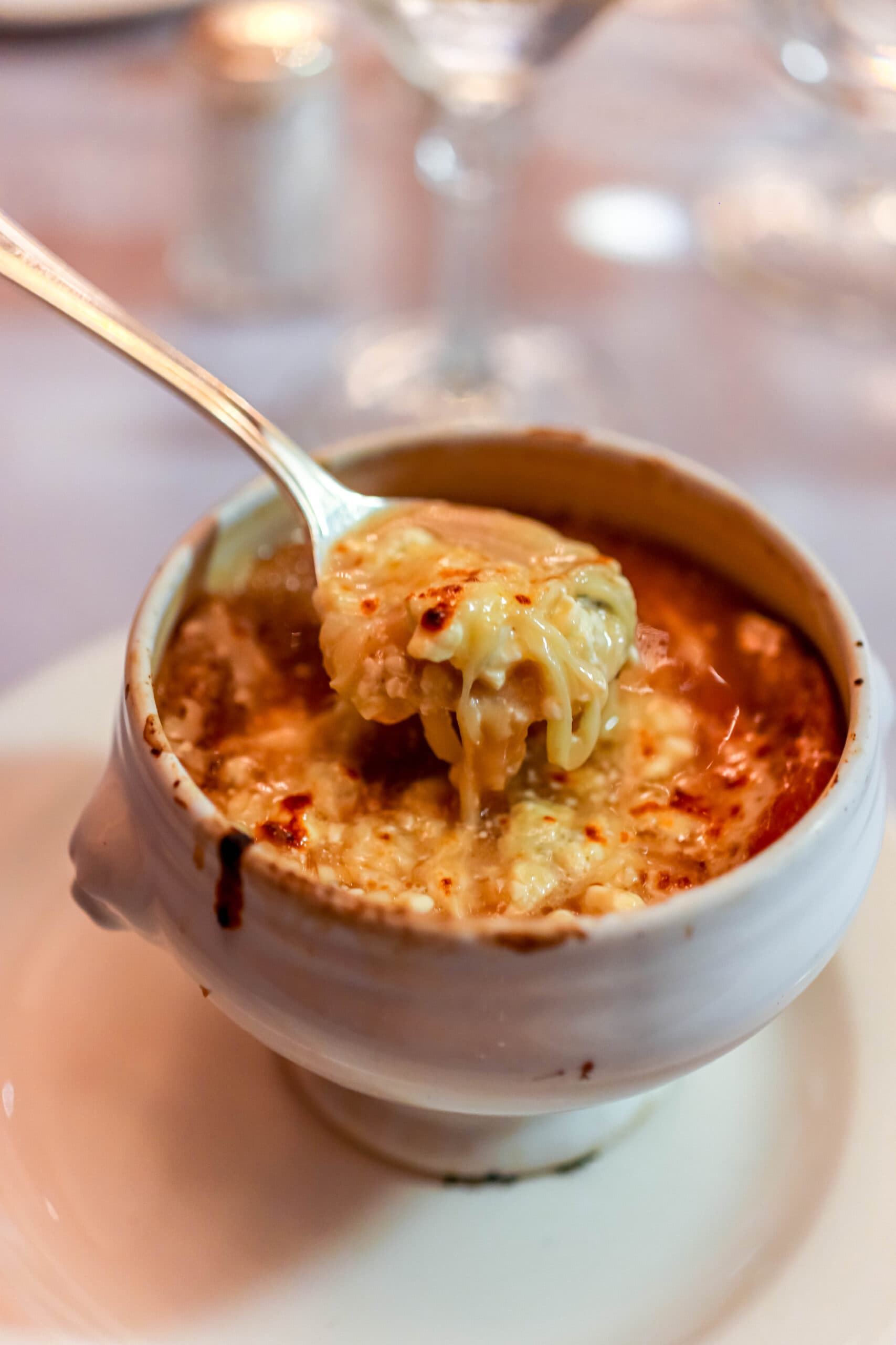 Your Ultimate Dining Guide for the Majestic Princess 21 A rich, flavorful bowl of soup with a spoon, offering a comforting start to dinner at Crown Grill on Majestic Princess.