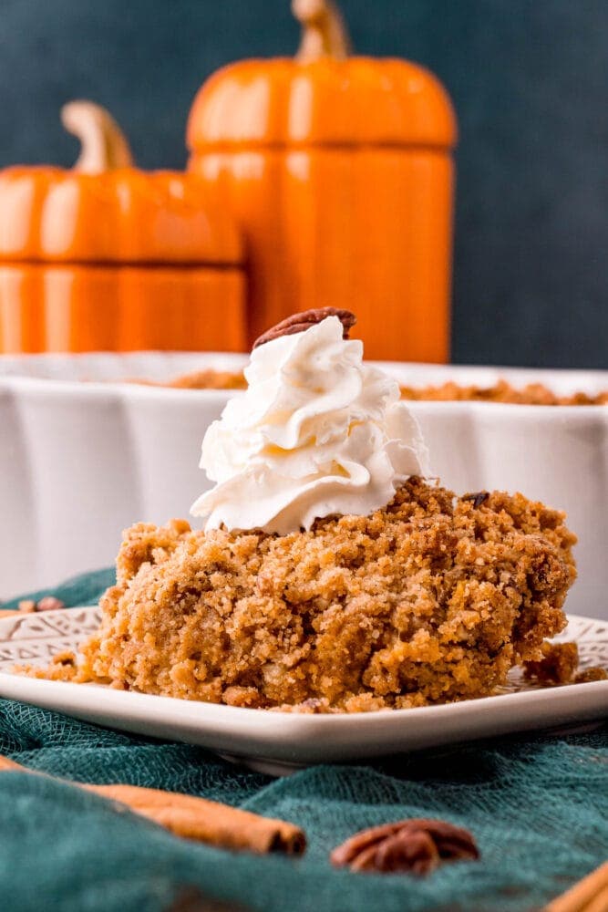 picture of pumpkin crisp on a plate with a drop of whipped cream on top