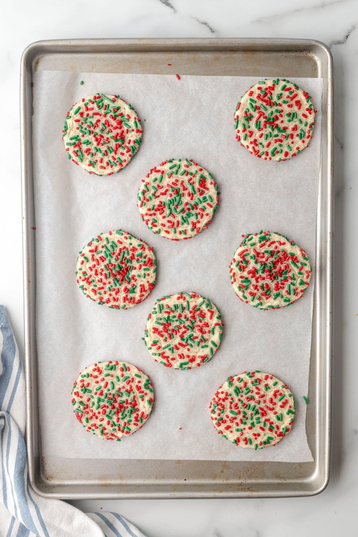 Christmas cookies with red and green sprinkles on a baking sheet.