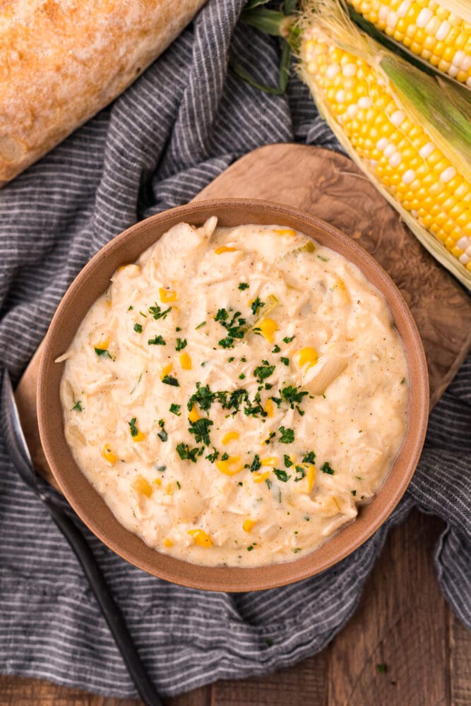 picture of corn chowder with shredded chicken in a bowl with parsley on top