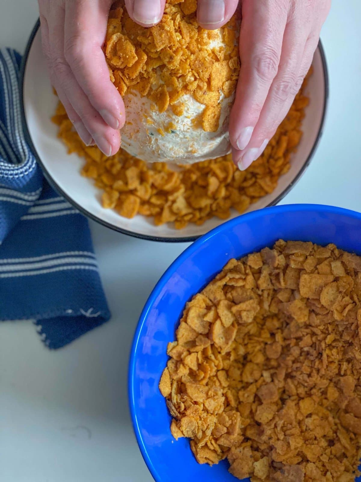 picture of hands rolling cheese ball in fritos