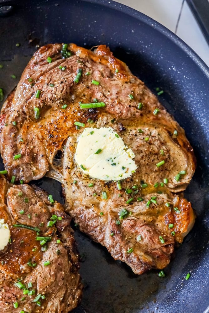 picture of ribeye steak with a pat of clarified butter in a pan 