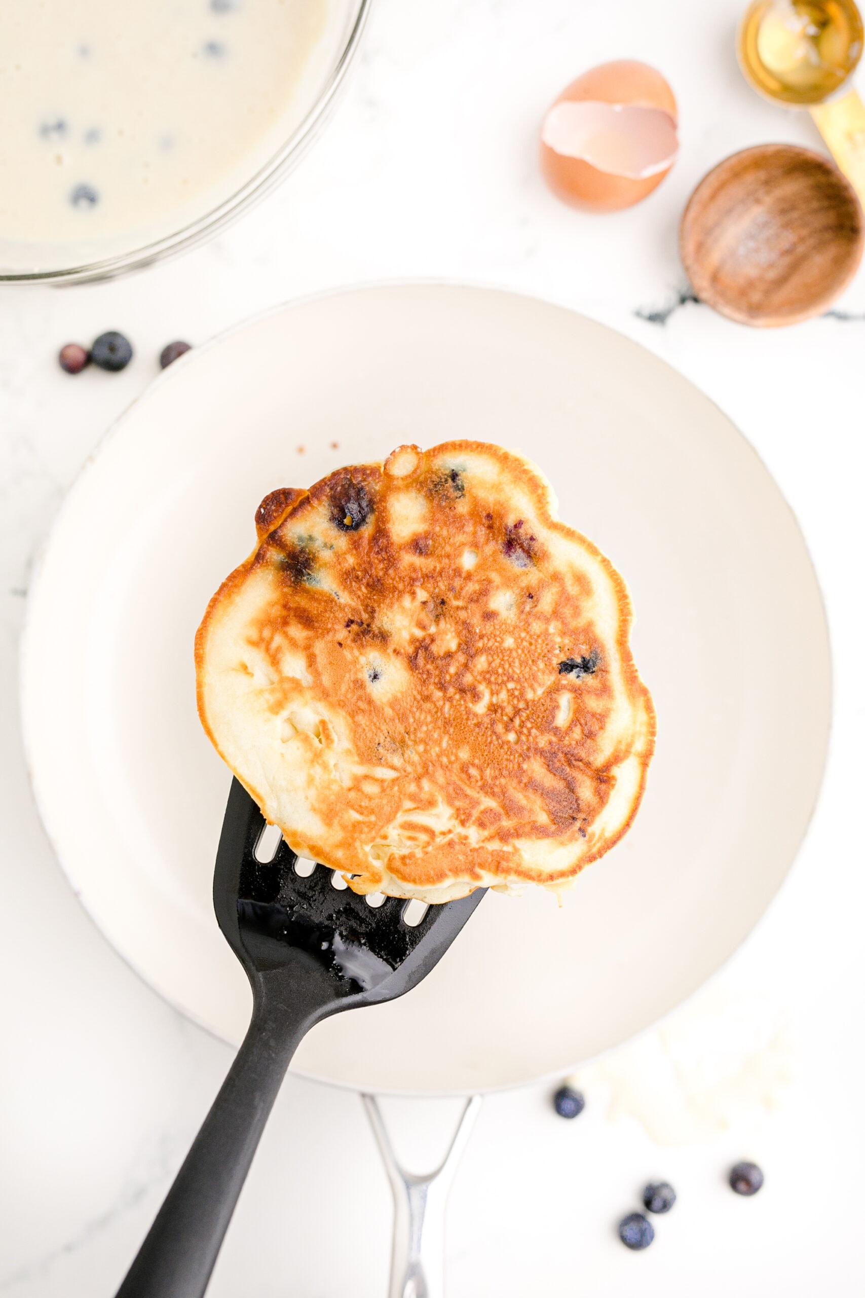 Blueberry pancakes on a plate with a fork.