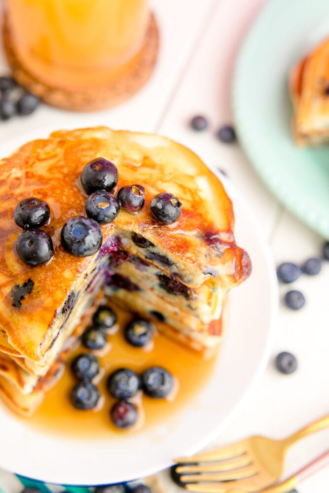 picture of blueberry pancakes with syrup in a stack 