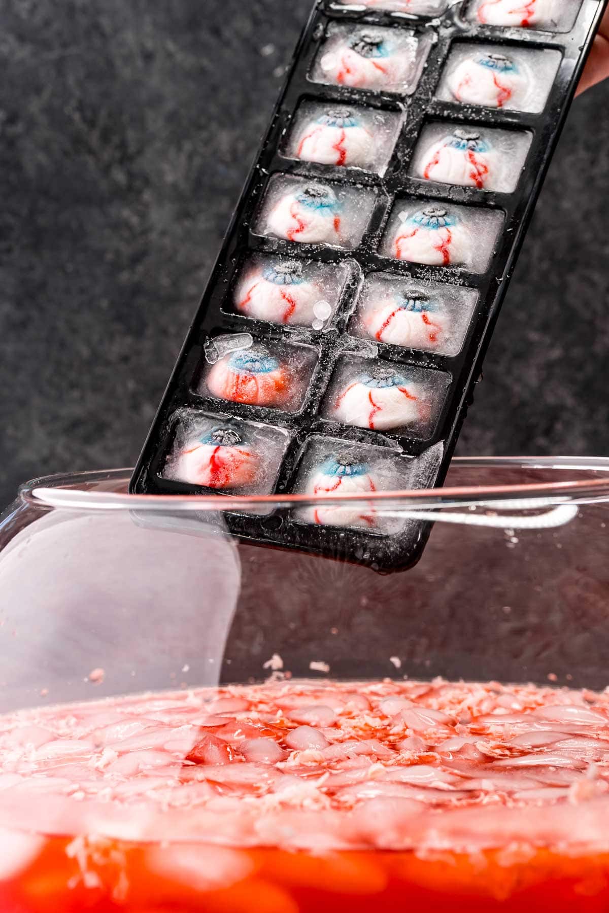 picture of gummy ice eyes being added into punch bowl