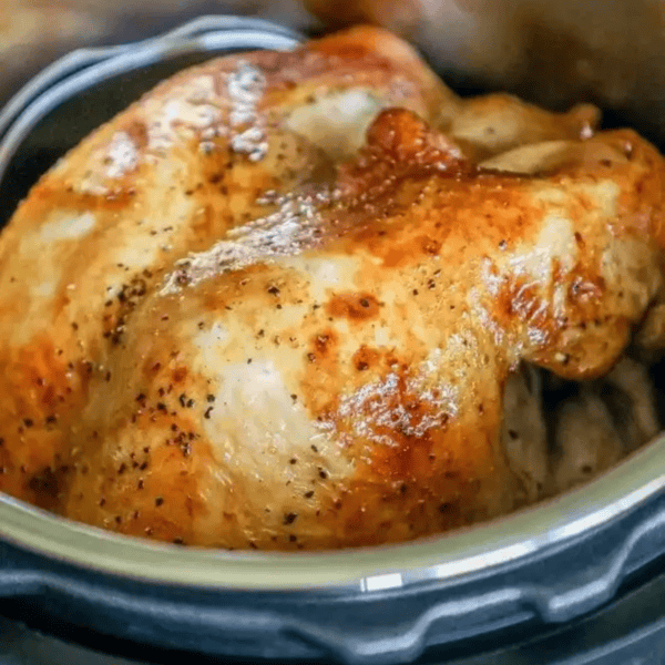 A golden-brown roasted whole chicken cooked in an Instant Pot.