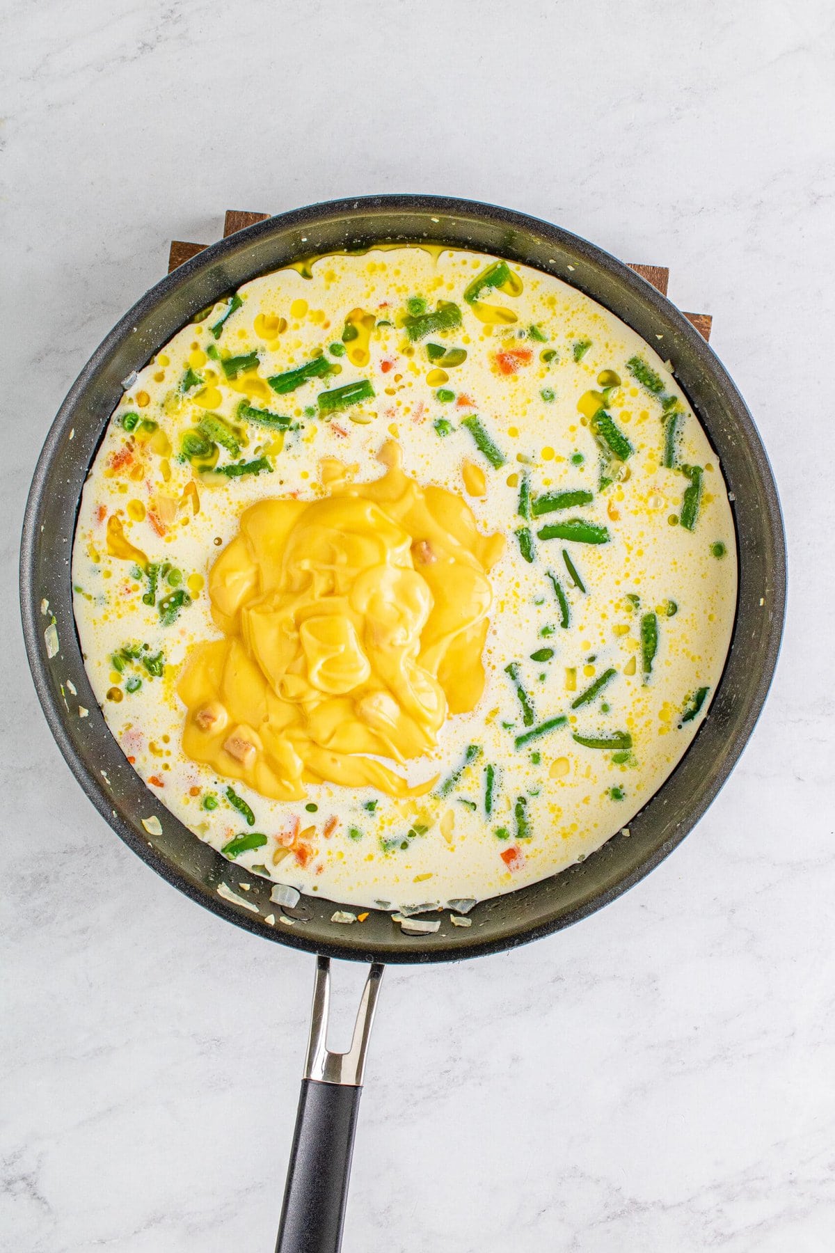 picture of soup being added to pan with milk and vegetables