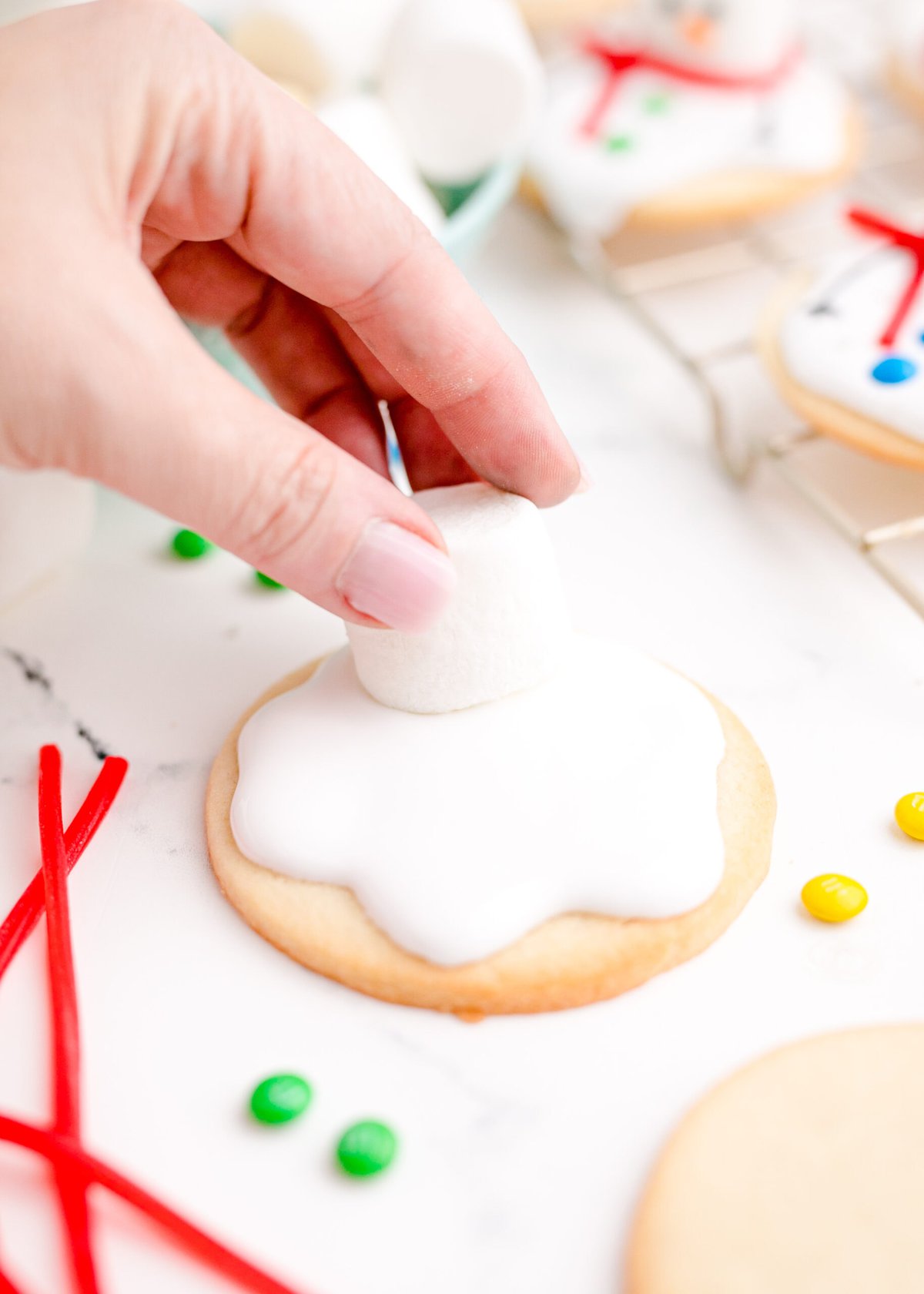 picture of a hand putting a marshmallow on a cookie