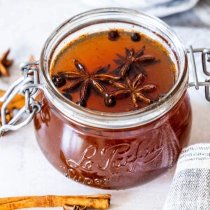 picture of mulled simple syrup in a jar with star anise and juniper berries floating on top