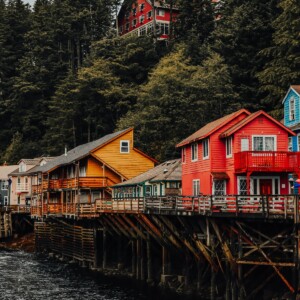 Colorful houses on a pier in Ketchikan, Alaska, next to a body of water.