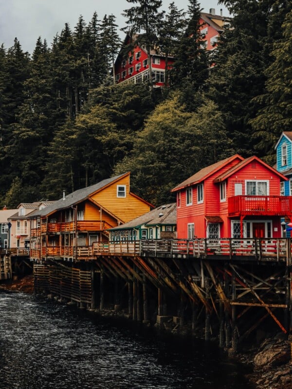 Colorful houses on a pier in Ketchikan, Alaska, next to a body of water.