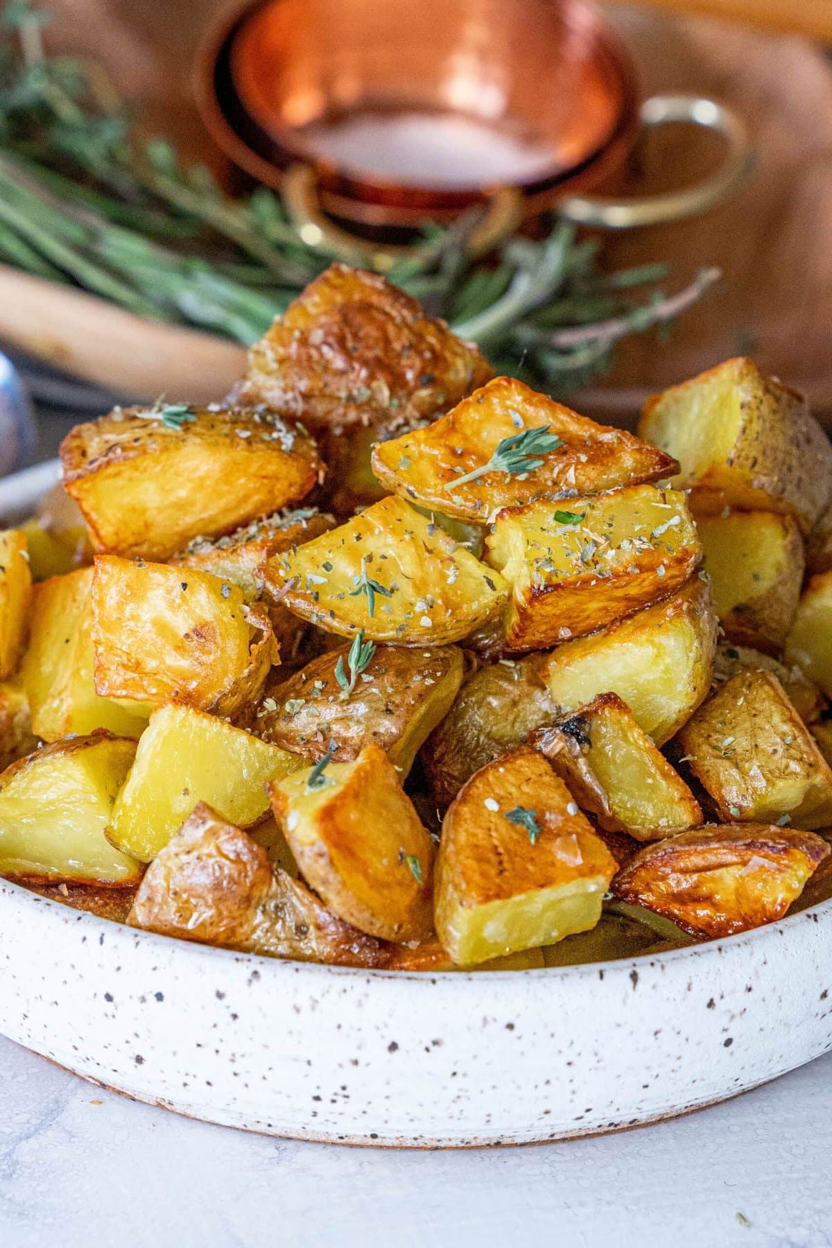Crispy roasted potatoes garnished with rosemary.
