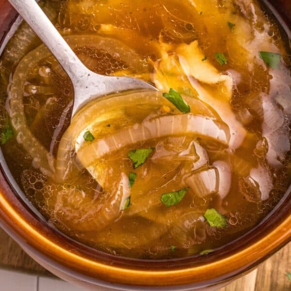 Easy French Onion Soup Recipe served in a bowl with onions and a spoon.