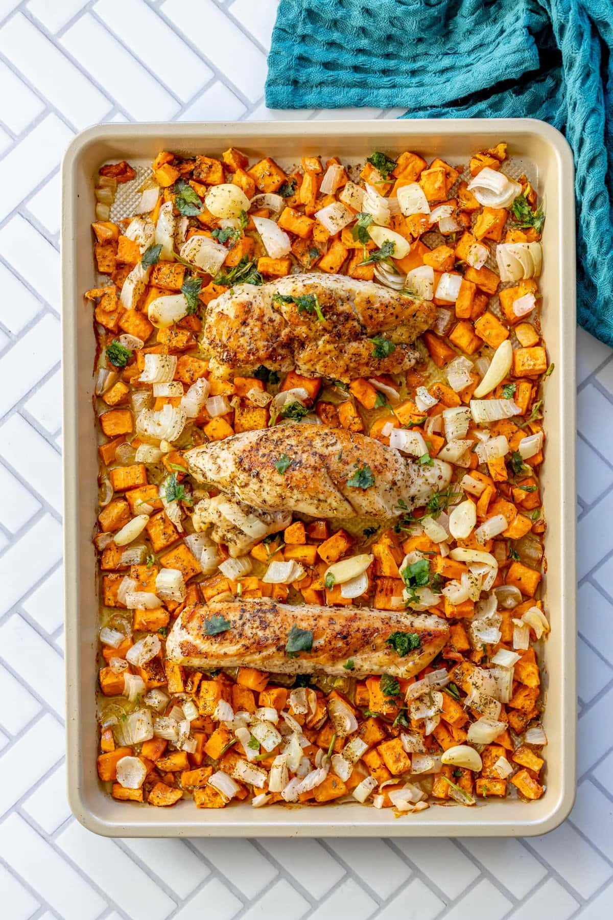 picture of baked onions sweet potatoes and pork on a baking sheet