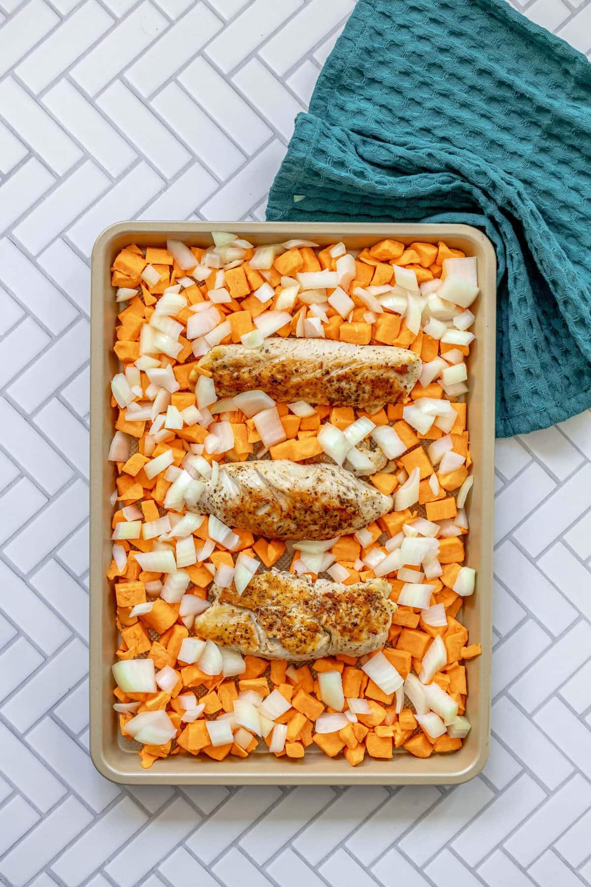 picture of turkey tenderloins and sweet potatoes and onions on a baking sheet