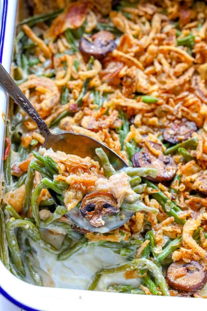 picture of green bean casserole in baking dish with crunchy onions on top 