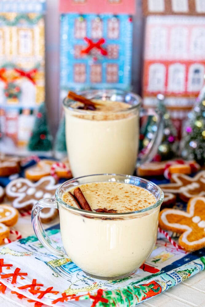 a f glass mug with eggnog in it and a stick of cinnamon and star of anise on top