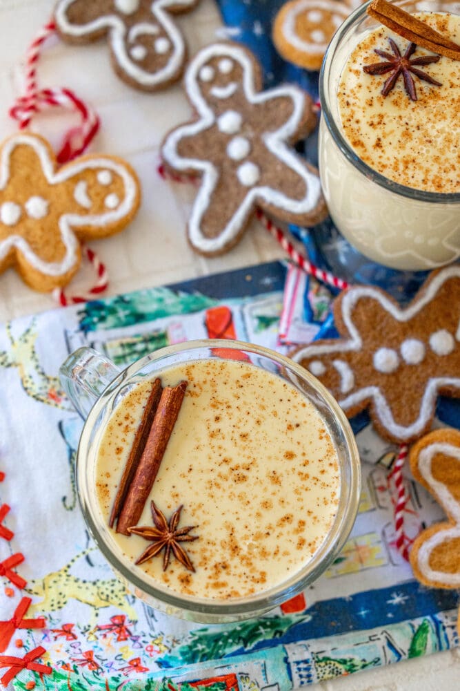 picture of glass mug with eggnog in it and a stick of cinnamon and star of anise on top