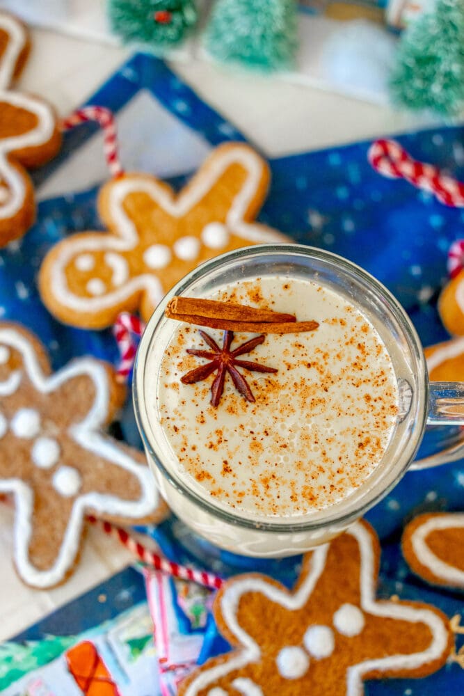picture of glass mug with eggnog in it and a stick of cinnamon and star of anise on top