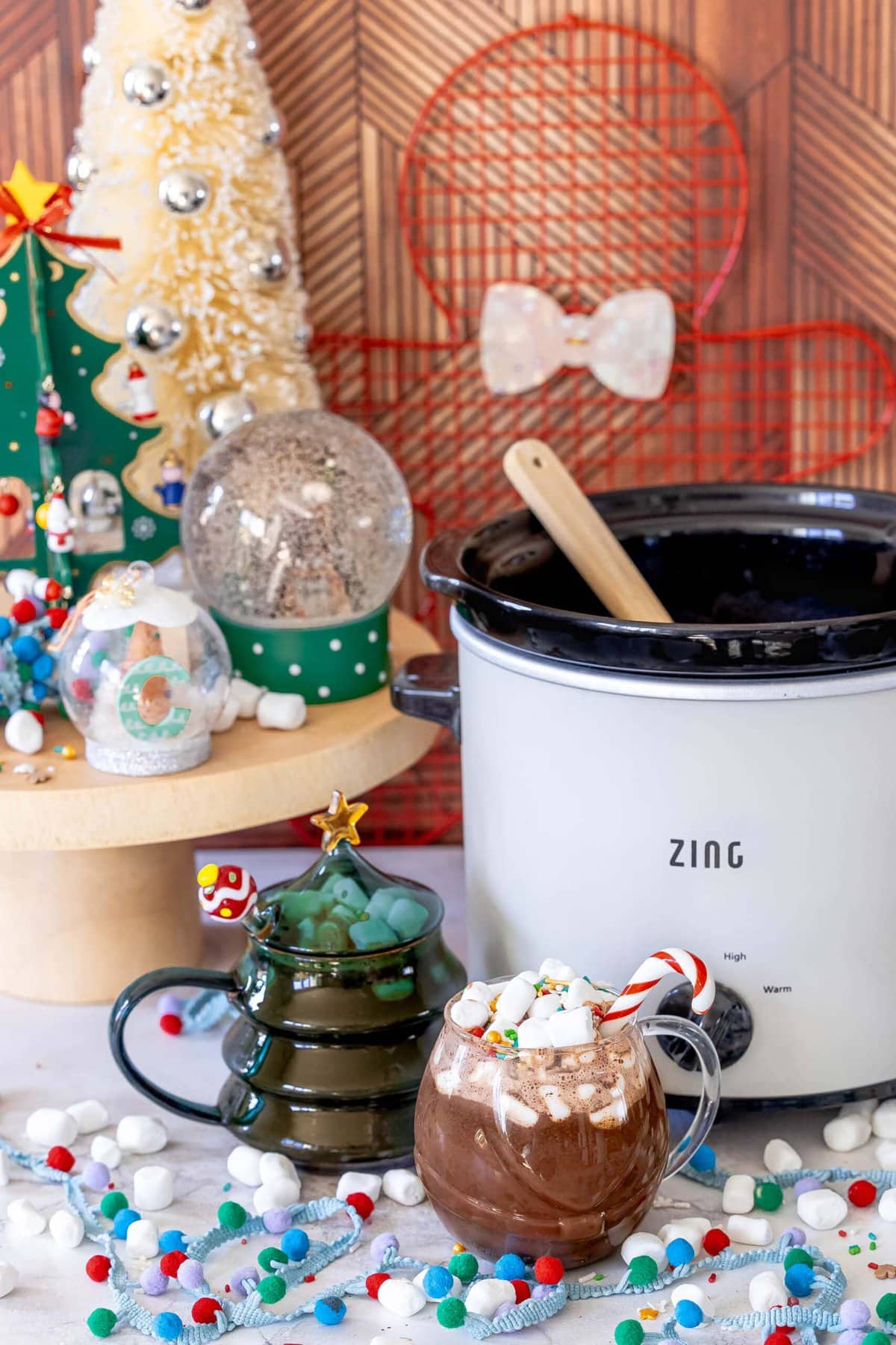 Rich and Creamy Slow Cooker Hot Chocolate 11 A cozy mug of slow cooker hot chocolate, featuring a candy cane stirrer and a fluffy layer of mini marshmallows, ready to be enjoyed.