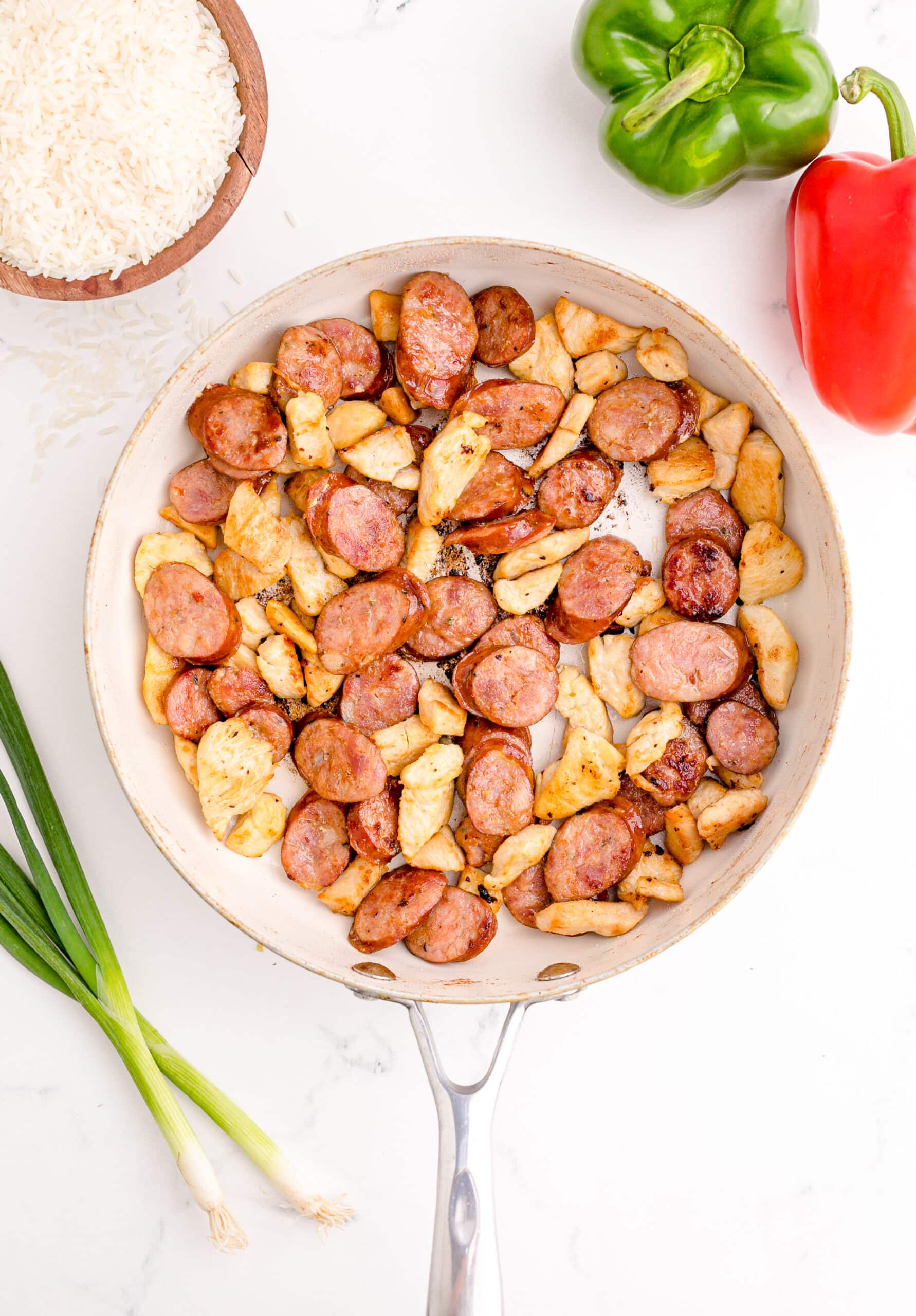 picture of chicken and sausage browning in a pan