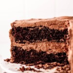 A homemade slice of black magic chocolate cake on a white plate.
