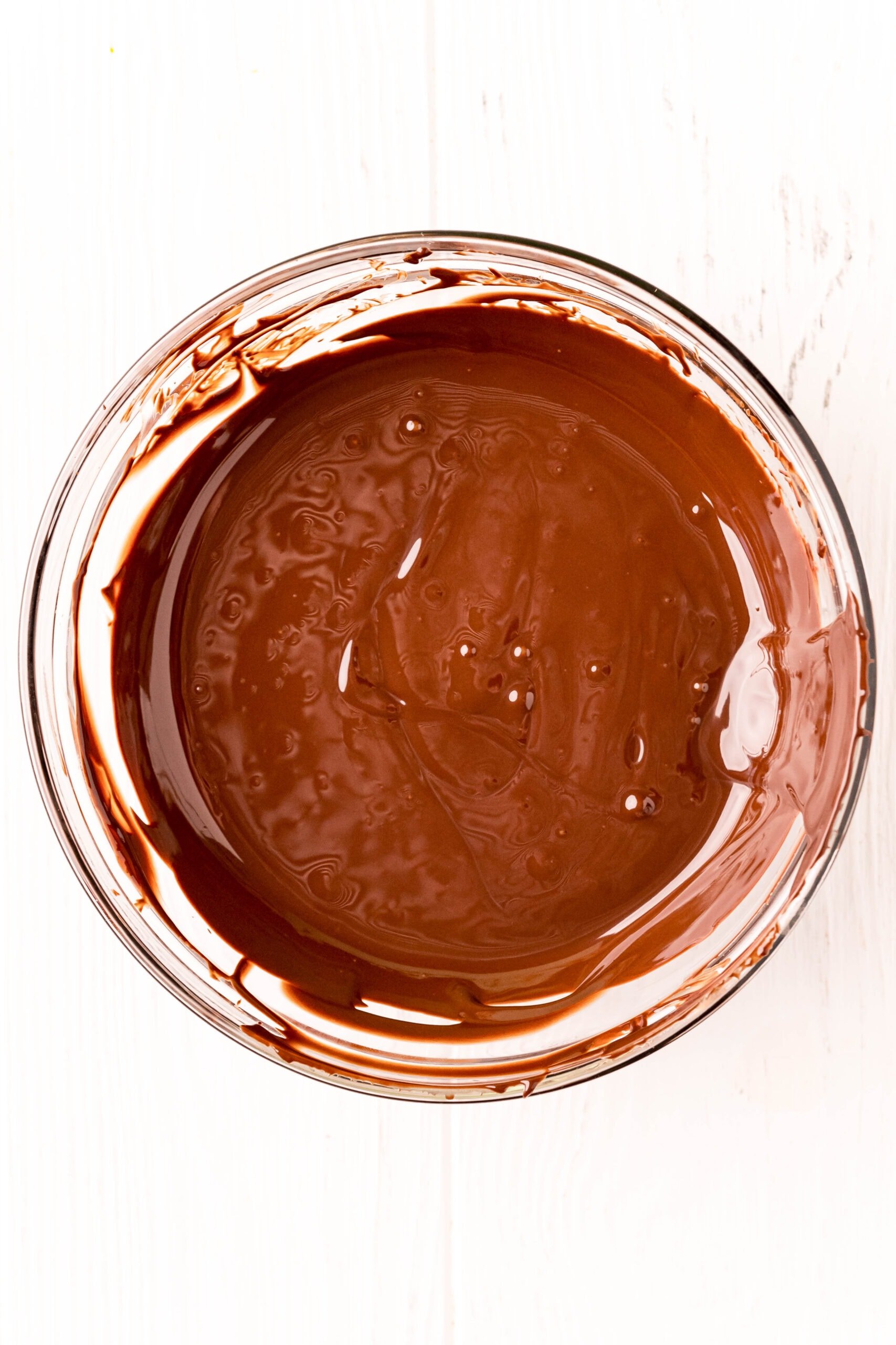 Homemade chocolate pudding frosting in a bowl on a white background.