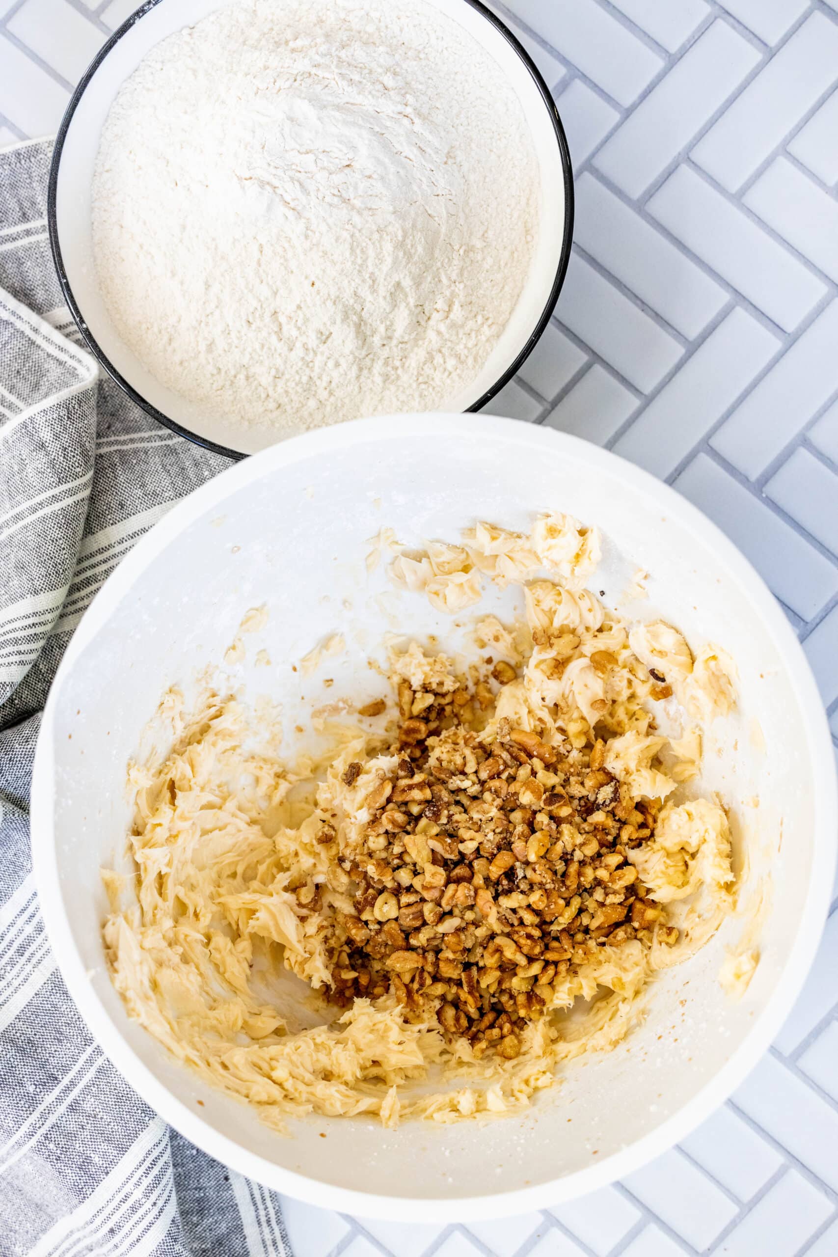 picture of cookie dough in a bowl with nuts poured into the bowl