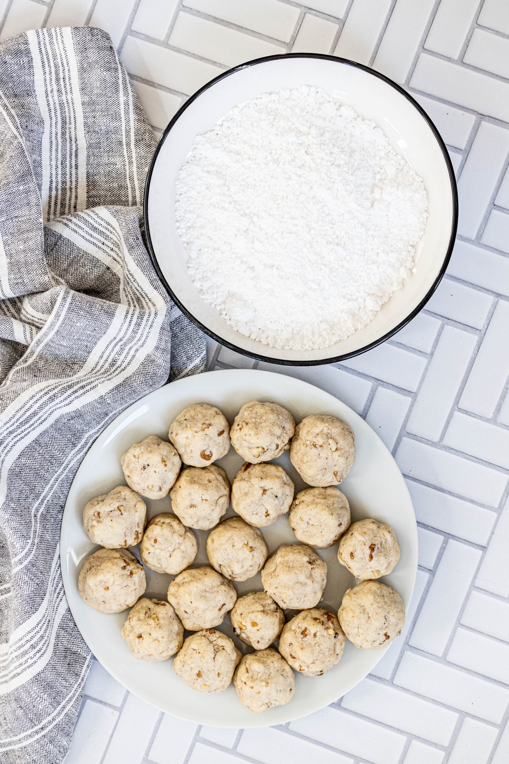 picture of cookies in a bowl next to a bowl of powdered sugar