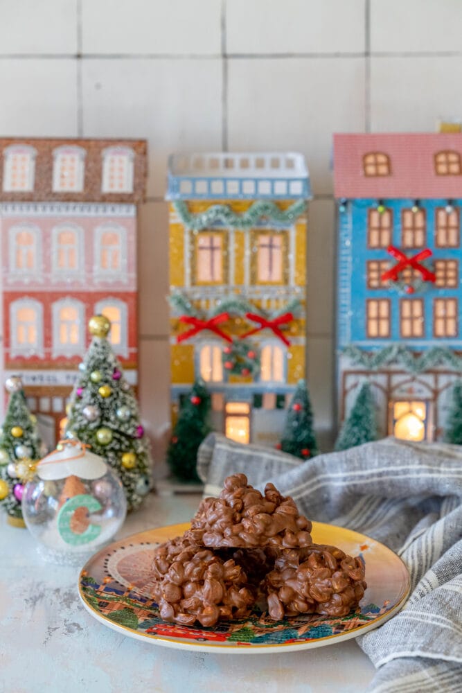 peanut clusters on a plate in front of christmas decorations