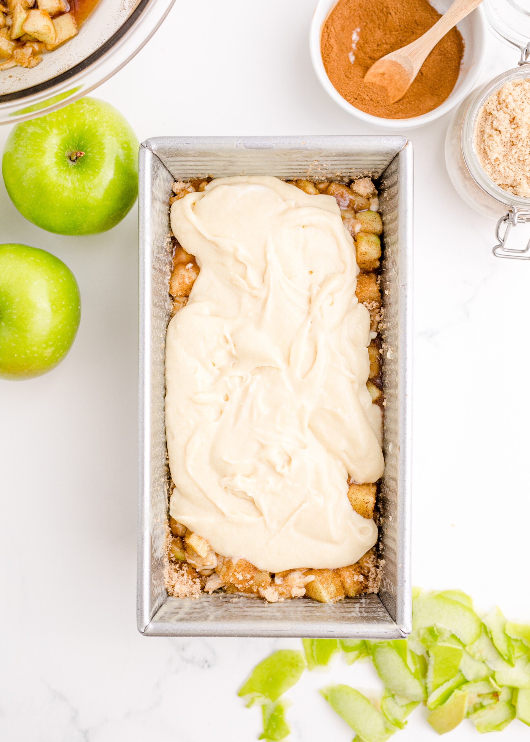 picture of batter poured over apples in a pan