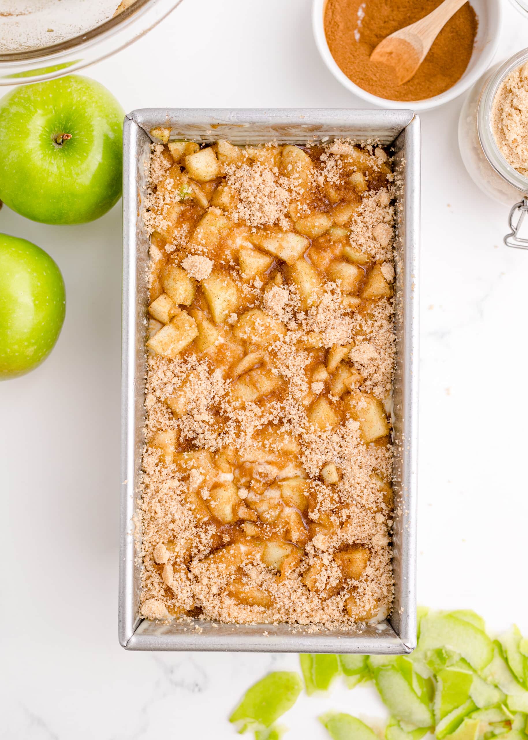 picture of apples and sugar over batter in a pan