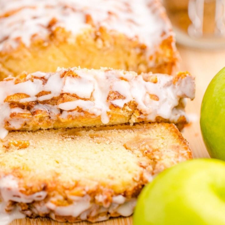 picture of apple fritter bread sliced on a cutting board with a green apple in front of it