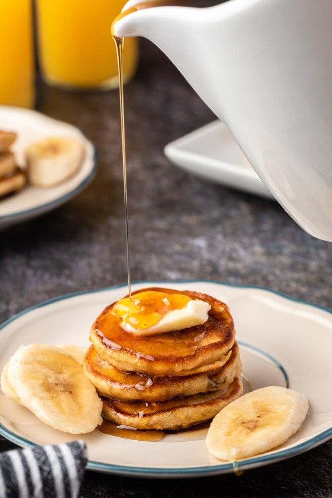 picture of a stack of pancakes with syrup being poured over the top 