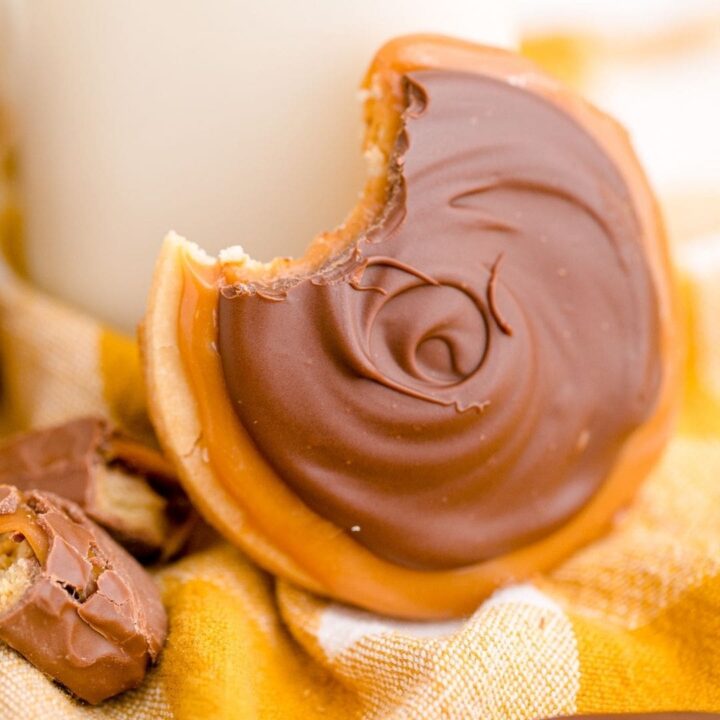 picture of a twix cookie with a bite out of it next to a bottle of milk