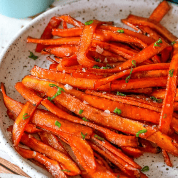 Roasted carrots on a plate with parsley, perfect for vegans.