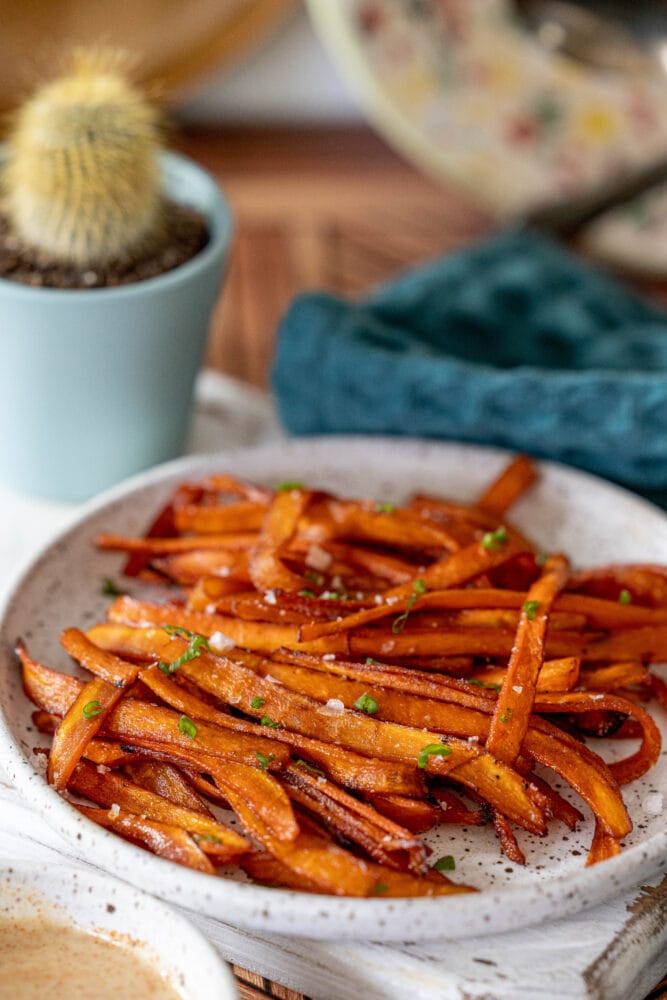 picture of carrot bacon on a plate with chives on and salt top 