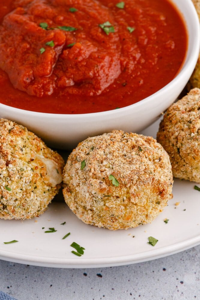 picture of air fryer arancini ball on a plate with sauce