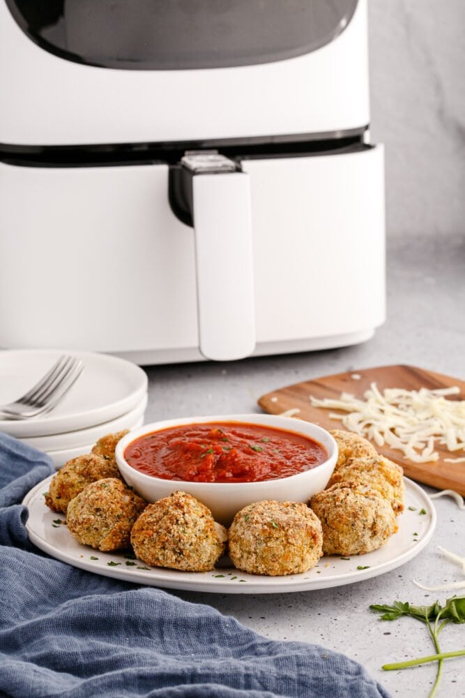 picture of air fryer arancini ball on a plate with sauce