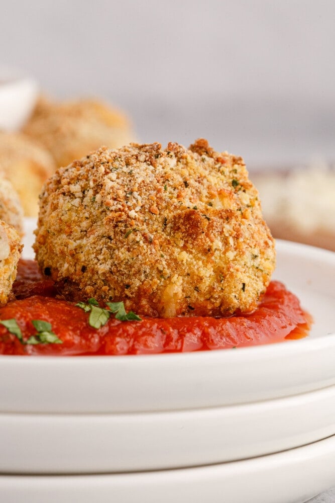 picture of air fryer arancini ball on a plate with sauce