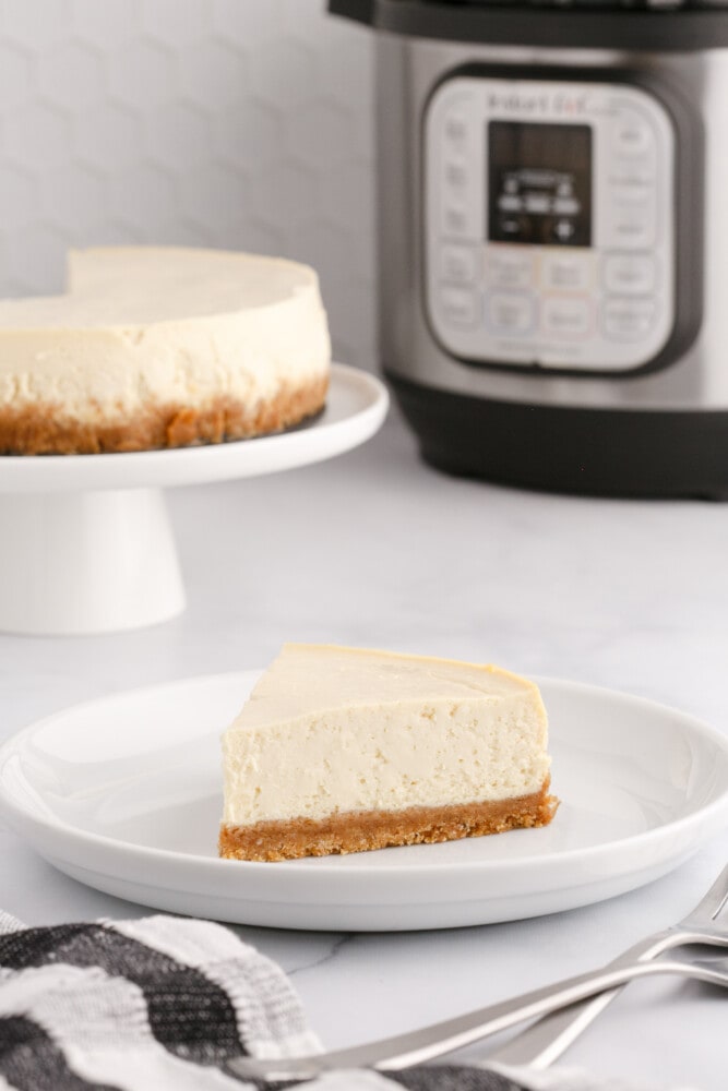 picture of cheesecake on a plate in front of an instant pot