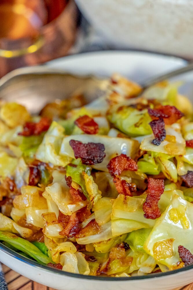 sautéed cabbage and bacon in a white bowl 