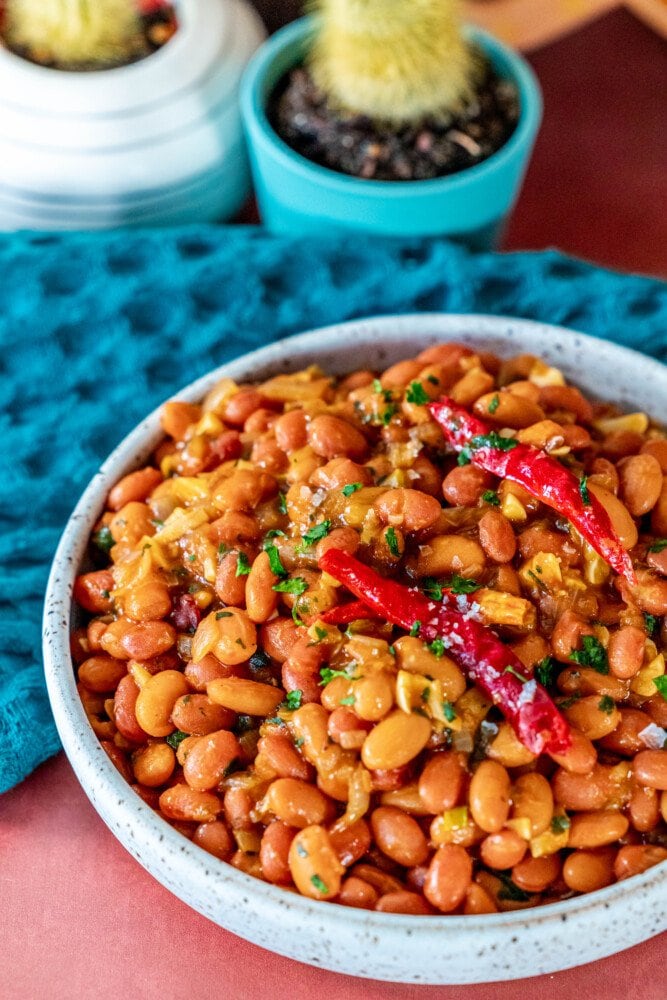 picture of spicy beans in a bowl with chiles and cilantro 