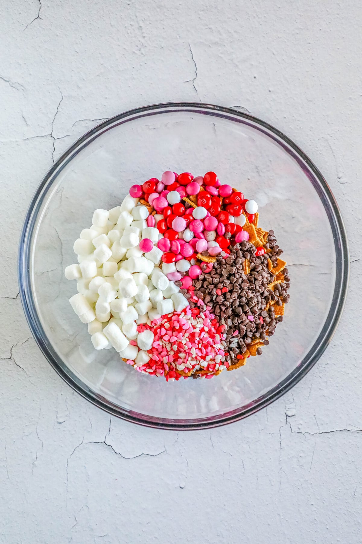 cereal, marshmallows, pink M&Ms, sprinkles, and chocolate chips in a bowl